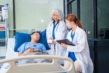 Fototapeta premium Two female doctors examine a patient lying on a hospital bed,discuss the medical chart,administer medicine,and provide encouragement, ensuring compassionate care and fostering the patient's recovery