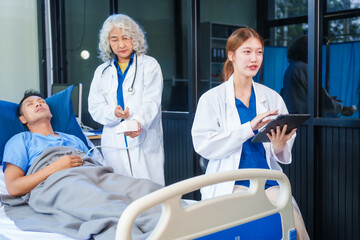 Obraz premium Two female doctors examine a patient lying on a hospital bed,discuss the medical chart,administer medicine,and provide encouragement, ensuring compassionate care and fostering the patient's recovery