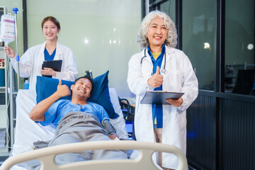 Two female doctors examine a patient lying on a hospital bed,discuss the medical chart,administer medicine,and provide encouragement, ensuring compassionate care and fostering the patient's recovery