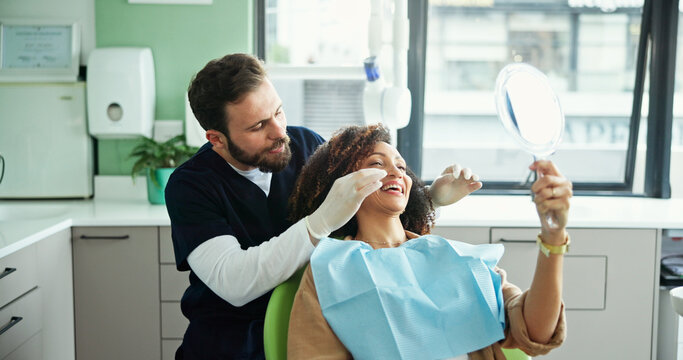 Dentist, happy and woman with mirror to check for consulting, teeth whitening and wellness. Healthcare, dentistry and man with patient for dental hygiene, oral cleaning and medical services in clinic