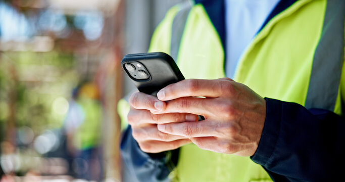 Hands, phone and construction site with texting, person or contact with info for building development. Engineer, smartphone and check with network, notification and mobile app at property in Spain - Powered by Adobe