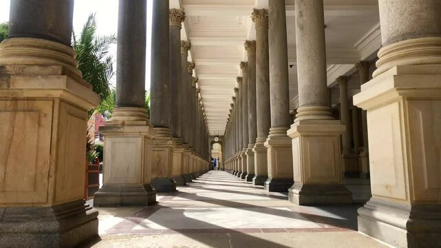 Building with rows of large stone columns. Mill Colonnade hot springs in the resort tourist town of Karlovy Vary, Czech Republic.