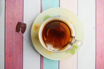 A Cup of Aromatic Tea Resting on a Colorful Wooden Table Surface
