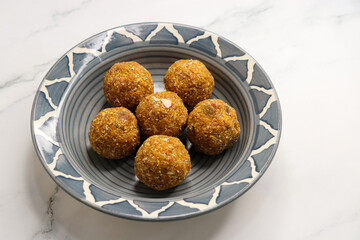 Gond and methi ke laddoo. Sweet Dink laddu also known as Dinkache ladu in Marathi. Recipe ingedients such as fry fruits, Fenugreek seeds, Khaskhas, Edible gum, Garden Cress Seeds, sugar. copy space.