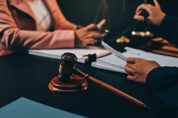 Judge gavel with Justice lawyers having team meeting at law firm background. Concepts of Law and Legal services.