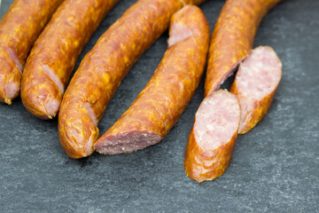 The hunting sausages are on a black Cutting board. food preparation cutting.