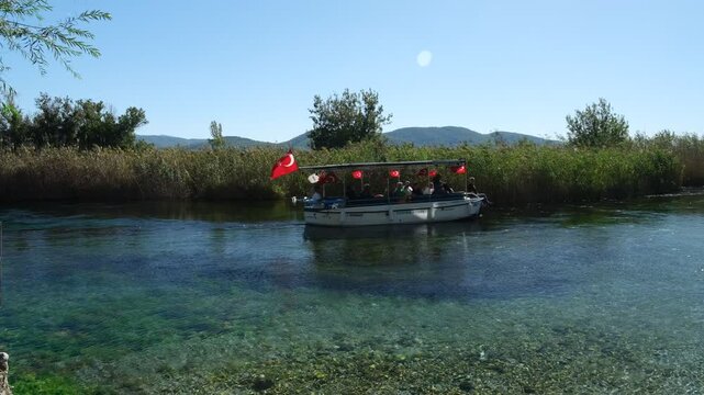 Ula, Mugla,Turkey, Akyaka Azmak river. Boat trip on the turquoise color river. Akyaka is a popular tourist centre in Turkey 