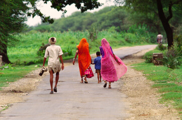 Indian rural family man woman children going home India