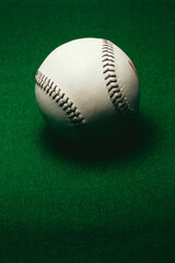 white baseball on green background