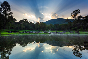 Hot springs over rock terrain with misty and morning sunrise rays and Natural Mineral Water of Chae Son National Park in Lampang Province, Thailand.