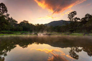 Hot springs over rock terrain with misty and morning sunrise rays and Natural Mineral Water of Chae Son National Park in Lampang Province, Thailand.