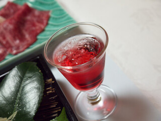 Shot glass of red Japanese aperitif liquor welcome drink for starting traditional ryokan dinner
