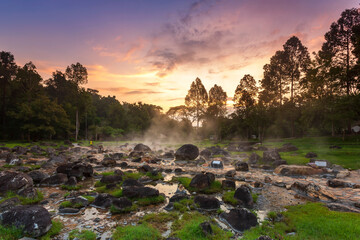 Hot springs over rock terrain with misty and morning sunrise rays and Natural Mineral Water of Chae Son National Park in Lampang Province, Thailand.