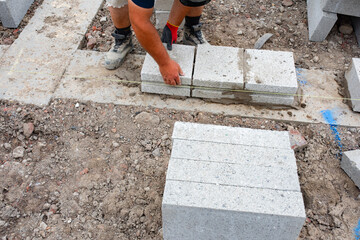 Bricklayer laying concrete blocks on a construction site in bright daylight during the afternoon