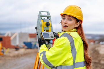 Pretty woman urveyor using advanced equipment at a construction site during overcast weather in an urban area