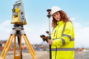 Female surveying professional uses equipment on construction site to ensure accurate measurements for building projects