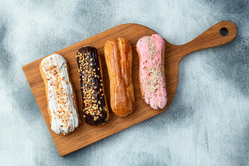 Assorted eclairs on a pastel top view Traditional French dessert