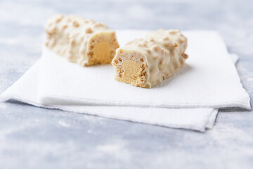 Protein bar in two pieces on wooden background. Soft focus. Close up. Copy space