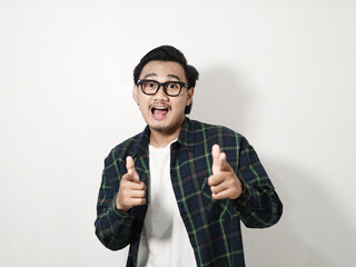 Fototapeta premium A portrait of an Asian man wearing a plaid shirt and glasses, pointing in a certain direction with both hands, Isolated with a white background.