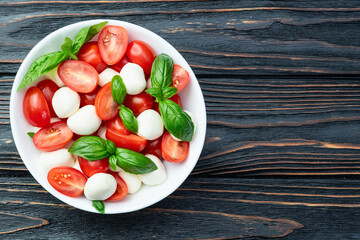 Basil leaves , cherry tomatoes and mozzarella cheese . In bowl food photography