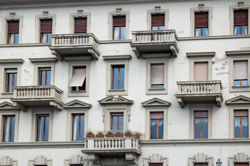 White facade of a house with stone balconies