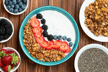 Healthy breakfast . Yogurt with berries ( strawberry , raspberry , blueberry , blackberry ) , granola and chia seeds . Top view