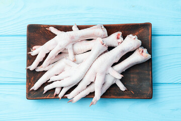 Raw chicken foot ( paws ) Top view on rustic background