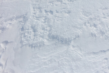 A snow covered ground with a few footprints