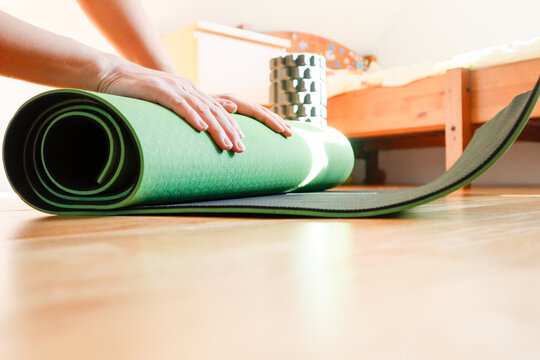 Green yoga mat close-up with a cozy home background