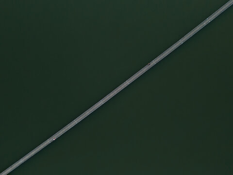 Fishermas on a bridge over a lake from above, dron view