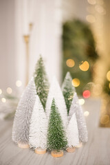 Forest of mini trees decorated in front of twinkle lights