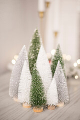 Mini decorating trees in front of twinkle lights