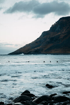 Surfers Braving the Waves at Unstad Beach in Lofoten