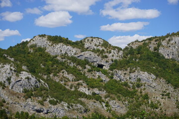 Montenegro Limestone Mountains with Caves and Greenery Under Blue Sky