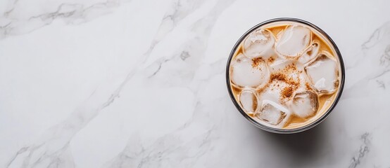 A refreshing iced coffee drink with ice cubes on a marble surface.