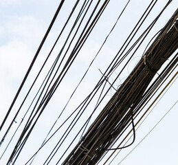 Obraz premium lots of tangled wires over the road and houses.