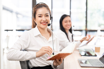 Obraz premium Beautiful asian businesswoman in call center consulting, speaking or talking at customer services.