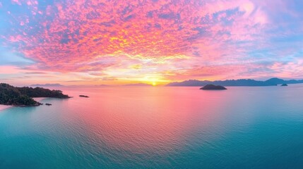 Naklejka premium A breathtaking sunrise over a calm ocean, with vibrant hues of orange, pink, and gold painting the sky.