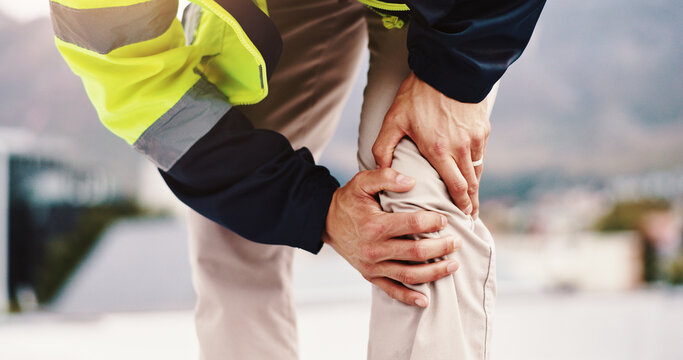 Person, architect and hands with knee pain for injury, construction accident or emergency in city. Closeup, civil engineer or contractor with joint inflammation, sore leg or sprain for arthritis