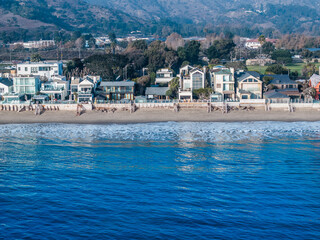 Aerial View of Coastal Residences and Rolling Waves