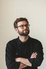 Obraz premium Confident Young Man with Glasses in Black Shirt Standing Against Neutral Background
