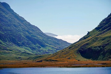 Scottish colorful landscape in glencoe valley with a lake in front and two mountains crossing each other