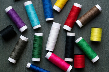 Colored thread coils on black table background, top view