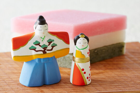 Hina dolls standing in front of water chestnut mochi