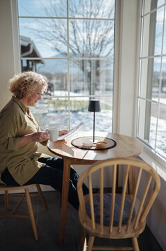 Middle-aged woman cheking report and drinking coffee.