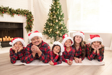 Family laying down in front of Christmas tree together