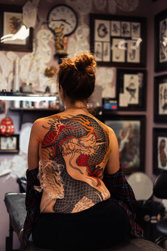 Traditional Japanese dragon tattoo in progress on a woman's back