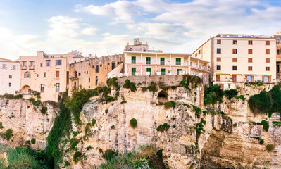 Fototapeta premium scenic travel landscape of beautiful historic town Tropea in Italy with old antique buildings, vintage houses on a high rock cliff above sea and amazing blue sky on background