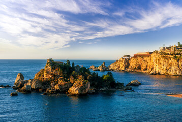 scenic sea shore view of island in ocean with waves and amazing cloudy sunset or sunrise on backgeound