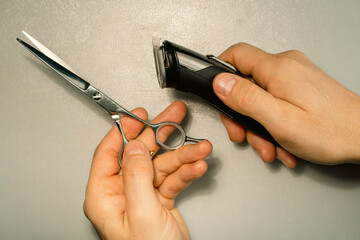 Hairdresser's hands holding hair cutting tools on white background.